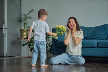 Anneler Günün kutlu olsun. Çocuk evlat tatilde annesini tebrik eder ve çiçek verir. Aile bağı, annelik.