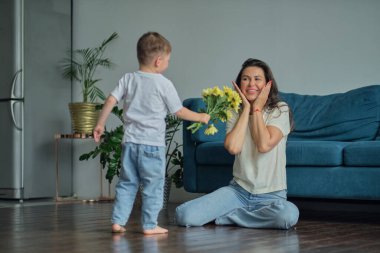 Anneler Günün kutlu olsun. Çocuk evlat tatilde annesini tebrik eder ve çiçek verir. Aile bağı, annelik.