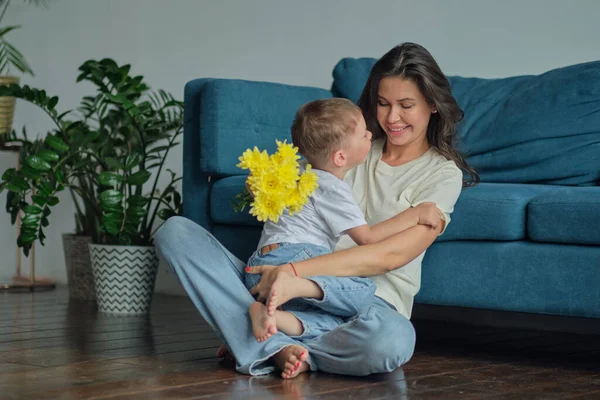 Anneler Günün kutlu olsun. Çocuk evlat tatilde annesini tebrik eder ve çiçek verir. Aile bağı, annelik.