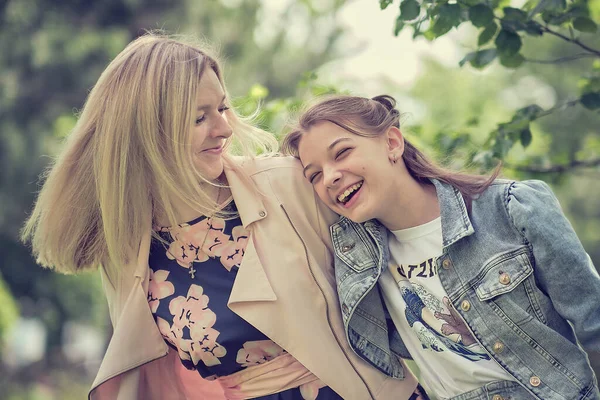 Happy mother with her daughter hugging a teenager in the summer. Caring happy mother enjoy day with teenage girl child, laugh have fun. Mother giving her daughter advice. — Stock Photo, Image