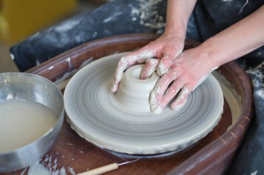 Kapalı kadın elleri kilden yemek yapar. Kadın elleri çömlekçi çarkında çalışıyor. Usta çömlekçi bir atölyede çalışıyor.