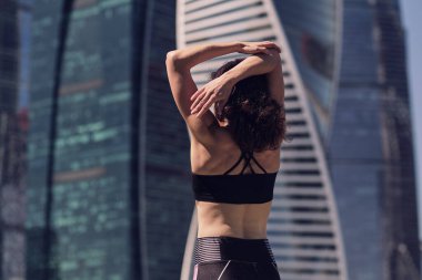 Sporcu orta yaşlı kadın antrenmandan önce ısınıyor, esneme egzersizleri yapıyor.