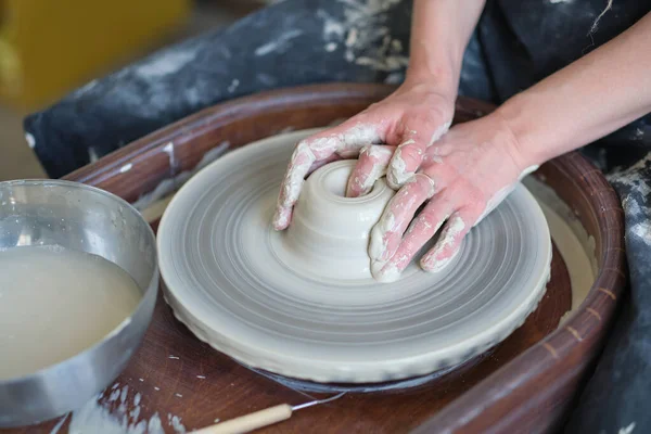 Kapalı kadın elleri kilden yemek yapar. Kadın elleri çömlekçi çarkında çalışıyor. Usta çömlekçi bir atölyede çalışıyor.