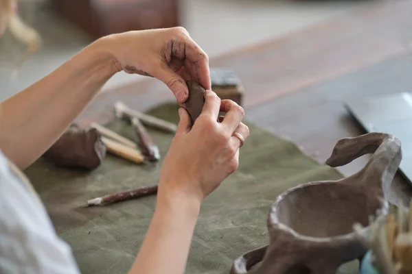 Поттер женского пола разминает кусок глины руками в мастерской. Керамика из глины своими руками. — стоковое фото