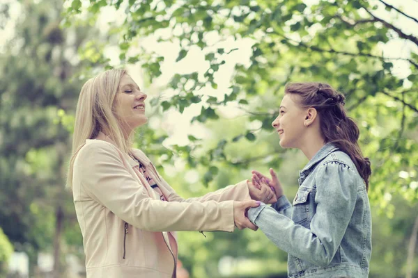 Happy mother with her daughter hugging a teenager in the summer. Caring happy mother enjoy day with teenage girl child, laugh have fun. Mother giving her daughter advice. — Stock Photo, Image