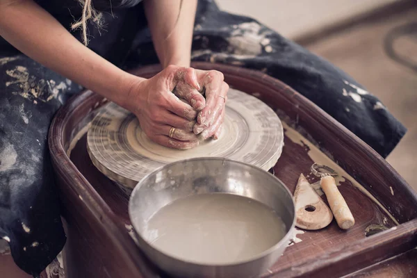 Close up female hands make dishes from clay. woman hands working on potters wheel. The master potter works in a workshop — Stock Photo, Image