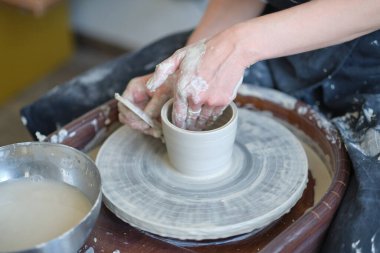 Kapalı kadın elleri kilden yemek yapar. Kadın elleri çömlekçi çarkında çalışıyor. Usta çömlekçi bir atölyede çalışıyor.