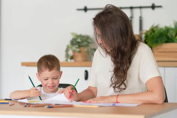 Lilla pojken lär sig att rita. Mamma och son har kul med att rita med pennor. Barnens kreativitet. — Stockfoto
