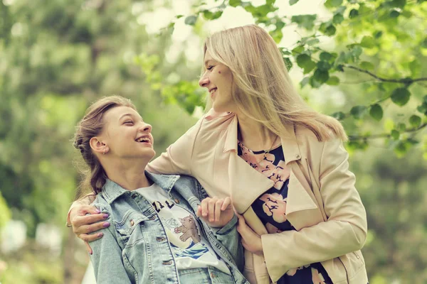 Lycklig mamma med sin dotter kramar en tonåring på sommaren. Vårda lycklig mor njuta av dagen med tonåring flicka barn, skratta ha kul. Mor ger sin dotter råd. — Stockfoto
