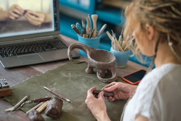工房で陶芸の講師をしています。女性セラミストはオンラインレッスンを教えたり、セラミック製品の作成についてビデオマスタークラスを指導したりします — ストック写真