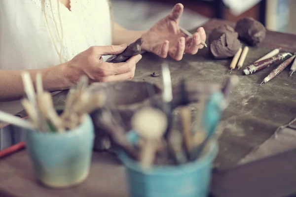 여자 도자기 예술가가 지저분 해. 여자들은 흰 진흙 조각을 흔들어 댑니다. 자기 손으로 진흙으로 만든 도기. — 스톡 사진