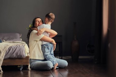 Anneler Günün kutlu olsun. Çocuk evlat tatilde annesini tebrik eder ve çiçek verir. Evde bayram kutlamaları sırasında anneler günü için onu tebrik etmek.
