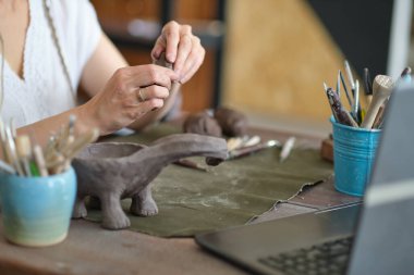 Sanat atölyesinde esnaf çömlek öğretmeni. Kadın seramikçi ya çevrimiçi bir ders veriyor ya da seramik ürünler üretmek için video ustası sınıfına öncülük ediyor.