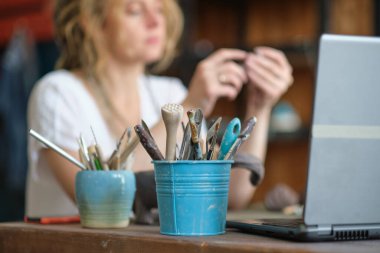 Sanat atölyesinde esnaf çömlek öğretmeni. Kadın seramikçi ya çevrimiçi bir ders veriyor ya da seramik ürünler üretmek için video ustası sınıfına öncülük ediyor.