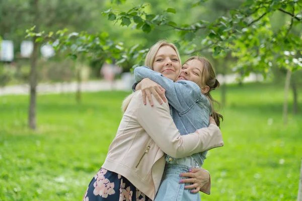 Szczęśliwa matka z córką przytulającą nastolatkę latem. Opiekuńcza szczęśliwa matka cieszyć dzień z nastolatką dziecko, śmiech baw się dobrze. Matka daje córce rady.. — Zdjęcie stockowe