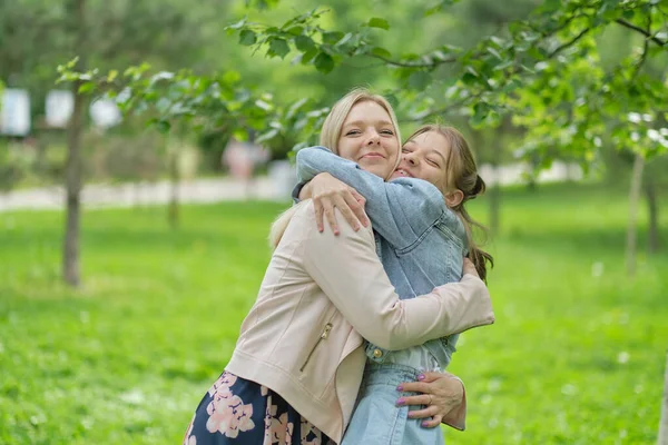 Mère heureuse avec sa fille embrassant un adolescent en été. Soins mère heureuse profiter de la journée avec l'adolescente enfant, rire avoir du plaisir. Mère donnant des conseils à sa fille. — Photo