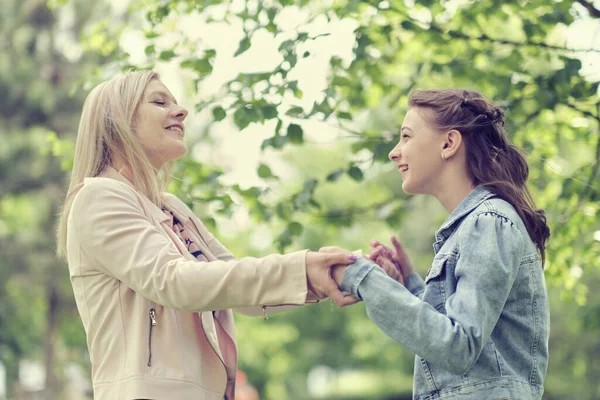 Eine glückliche Mutter mit ihrer Tochter, die im Sommer einen Teenager umarmt. Fürsorgliche glückliche Mutter genießen Tag mit Teenager-Mädchen Kind, lachen Spaß haben. Mutter gibt ihrer Tochter Rat. — Stockfoto