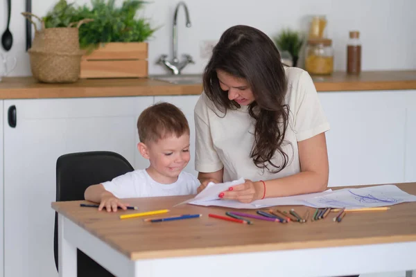 A kisfiú megtanul rajzolni. Anya és fia jó szórakozást ceruzával rajzolni. Gyermekkori kreativitás. — Stock Fotó