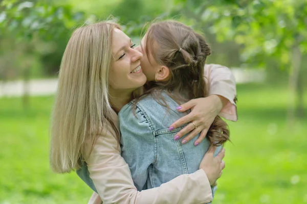 快乐的母亲和她的女儿在夏天拥抱一个少年。呵护快乐的母亲与年幼的女孩共度快乐的一天,笑得开心.母亲给女儿的忠告. — 图库照片