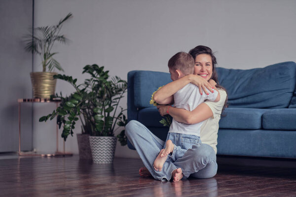 Happy mother day. child son congratulates mother on holiday and gives flowers. congratulating her on mothers day during holiday celebration at home