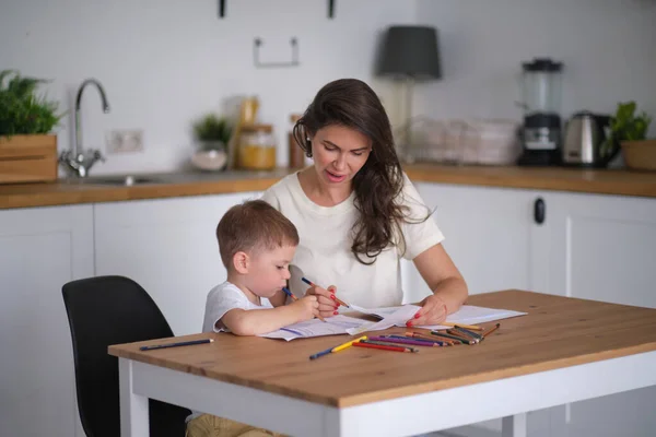 Lilla pojken lär sig att rita. Mamma och son har kul med att rita med pennor. Barnens kreativitet. — Stockfoto