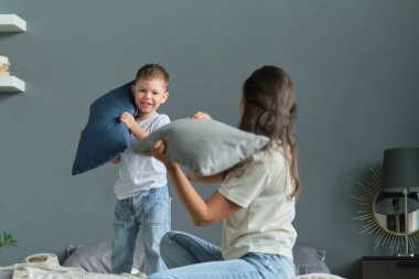 Anne, küçük oğluyla birlikte yatakta oynuyordu. Aile anları, çocukların bakımı. Annelik, annelik izni kavramı