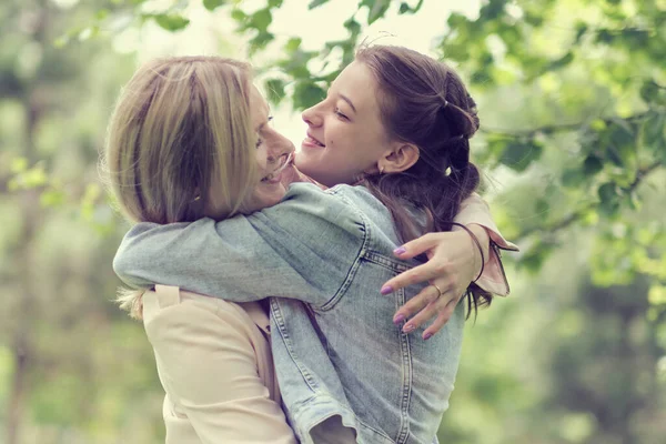 Madre felice con sua figlia che abbraccia un'adolescente in estate. La madre felice premurosa gode la giornata con il bambino adolescente, ride buon divertimento. Madre dando il suo consiglio figlia. — Foto Stock