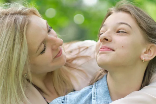 Eine glückliche Mutter mit ihrer Tochter, die im Sommer einen Teenager umarmt. Fürsorgliche glückliche Mutter genießen Tag mit Teenager-Mädchen Kind, lachen Spaß haben. Mutter gibt ihrer Tochter Rat. — Stockfoto