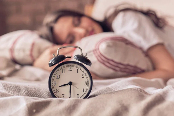 Frau mittleren Alters schlafend und Wecker im Schlafzimmer zu Hause. Schlafzeitkonzept — Stockfoto