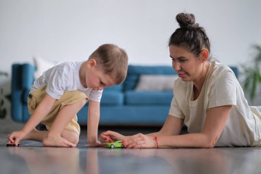 Annesiyle oyuncak arabasıyla oynayan etkileyici bir çocuk..