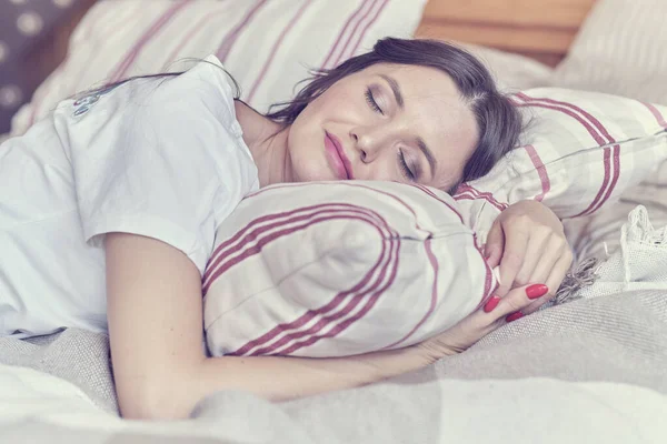 Frau im weißen T-Shirt schläft allein zu Hause auf dem Bett. — Stockfoto