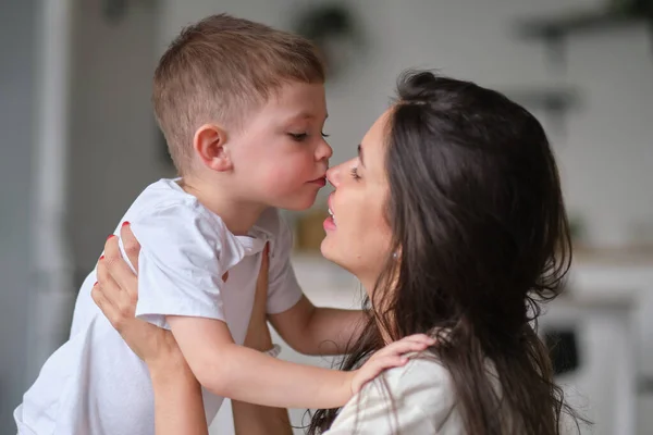 Chlapec políbí svou matku uvnitř. roztomilé dítě líbání maminka na nose. — Stock fotografie