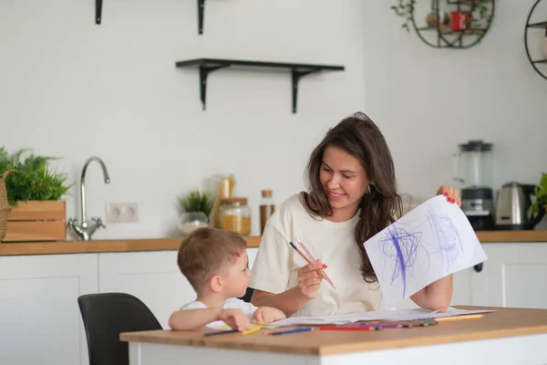 Lilla pojken lär sig att rita. Mamma och son har kul med att rita med pennor. Barnens kreativitet. — Stockfoto