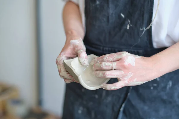 Hands of the ceramist shows the cut of the bowl. master demonstrates the quality of his work — Stock Photo, Image