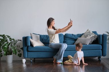 Bebek bakıcısı telefonda takılıyor ve bebeğe dikkat etmiyor.