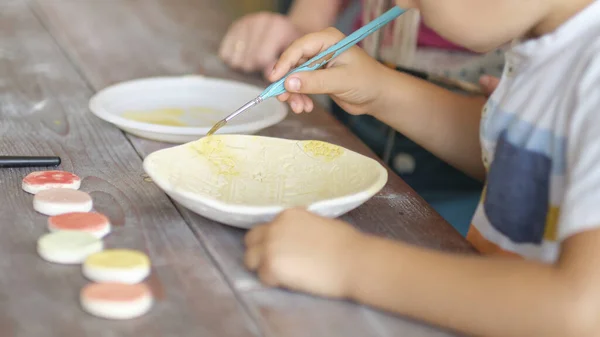Εργαστήρι για παιδιά. Τα παιδιά μαθαίνουν πώς να χρησιμοποιούν τον πηλό για να φτιάχνουν όμορφα πιάτα. Εργαστήριο, master class. — Φωτογραφία Αρχείου