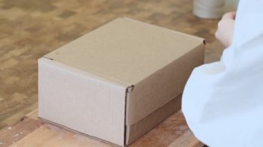 Girişimci kadın siparişi güzel bir kutuya koyar. Müşteriler için mükemmel bir servis..