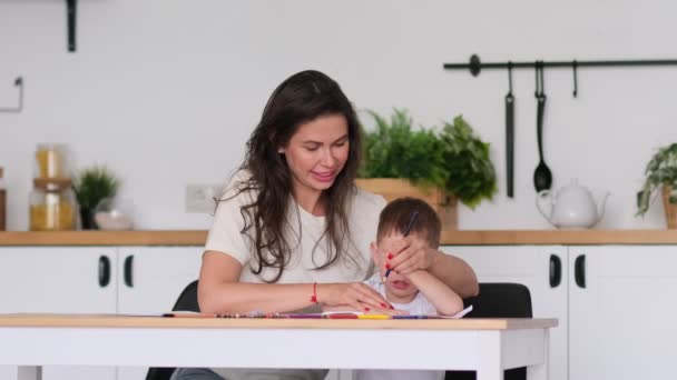 Chlapec se učí kreslit. Máma a syn se baví kreslením tužkami. Dětská tvořivost. — Stock video