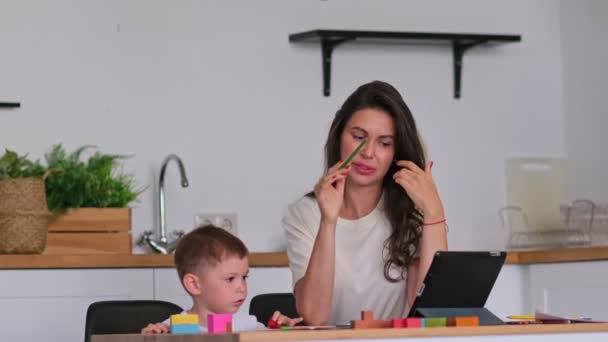 Moeder met jonge jongen met behulp van digitale tablet.happy mam en baby spelen educatieve online games op de tablet — Stockvideo