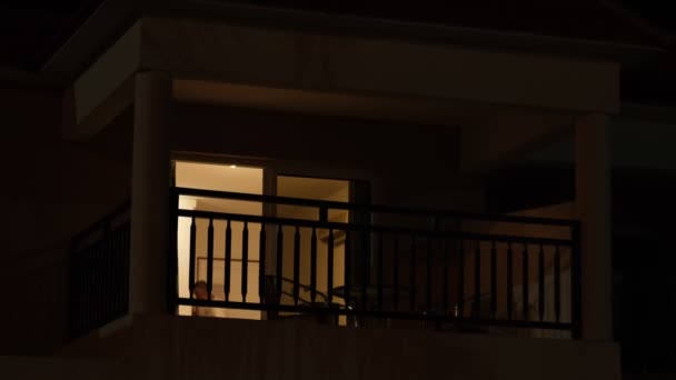 Light from the window of the house in the dark evening time. room lights up then turns off. — Stock Video