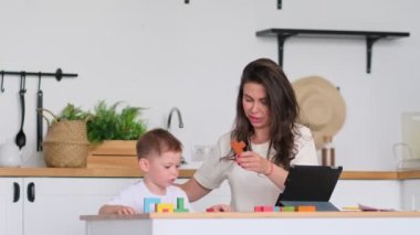 Anne ve genç çocuk dijital tablet kullanıyor. Mutlu anne ve bebek tablette eğitici online oyunlar oynuyor.