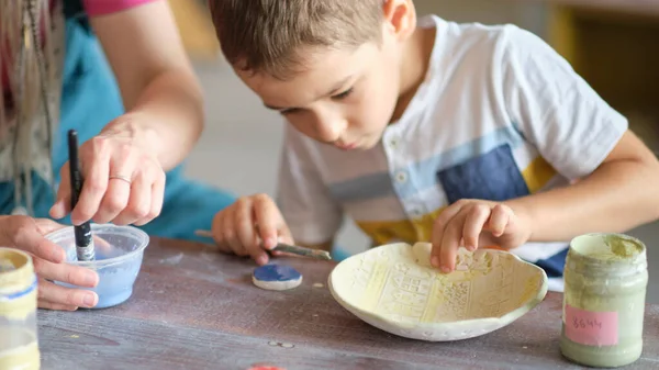 Εργαστήρι για παιδιά. Τα παιδιά μαθαίνουν πώς να χρησιμοποιούν τον πηλό για να φτιάχνουν όμορφα πιάτα. Εργαστήριο, master class. — Φωτογραφία Αρχείου