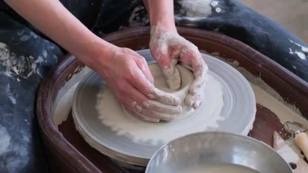 Close-up vrouwelijke handen maken borden van klei. vrouwenhanden werkend op pottenbakkerswiel. De meester pottenbakker werkt in een werkplaats — Stockvideo