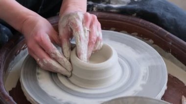 Kapalı kadın elleri kilden yemek yapar. Kadın elleri çömlekçi çarkında çalışıyor. Usta çömlekçi bir atölyede çalışıyor.