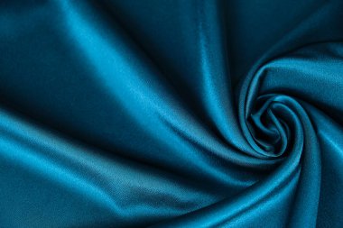 Mavi ipek kumaş ve avludan gelen döşeme kumaşı. Mavi saten, ipek kumaş, dalga, kumaş. Güzel tekstil arkaplanı. Yakın plan. Üst görünüm