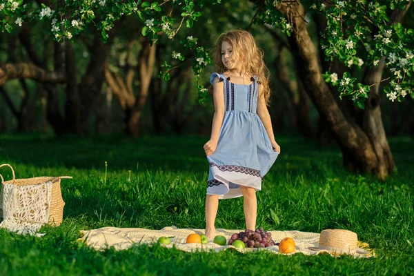 Menina feliz se divertindo no parque. Criança bonito sentado na grama em um dia ensolarado de verão. — Fotografia de Stock