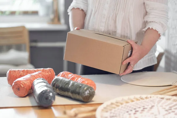 Femme entrepreneur emballe un produit fait à la main dans une boîte en carton. livraison de marchandises pour une petite entreprise. une femme âgée gagne son passe-temps de la maison. — Photo
