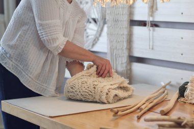 Kadın girişimci, karton bir kutuya el yapımı bir ürün koyar. Küçük bir iş için mal teslimatı. Yaşlı bir kadın hobisini evde kazanır..