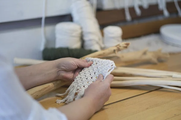 Base knots of macrame, the view from behind the shoulder close-up of the women hands, she ties knots. ECO friendly modern knitting DIY natural decoration concept. — Stock Photo, Image