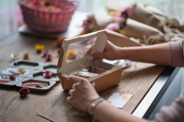 Küçük işletme sahibi, çevrimiçi pazarlama kutusu ve teslimatı. Kahverengi kağıda sarılı bir paket. Özel şirketler için teslimat konsepti. Tasarım hediye kutusu